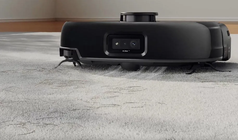Cleaning the cliff sensors on the underside of a eufy robot vacuum.