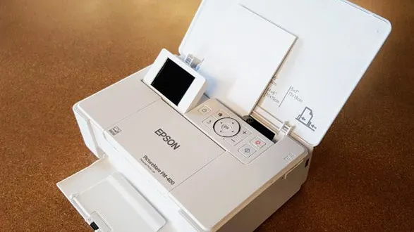 Clearing debris from the internal paper path of an Epson photo printer.