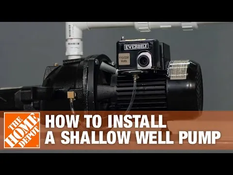 A close-up of a pipe connection on a shallow well pump showing potential leaks.