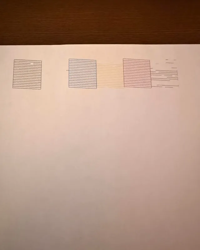 Hands carefully adjusting paper edge guides on an Epson ET-8550 printer feed tray.