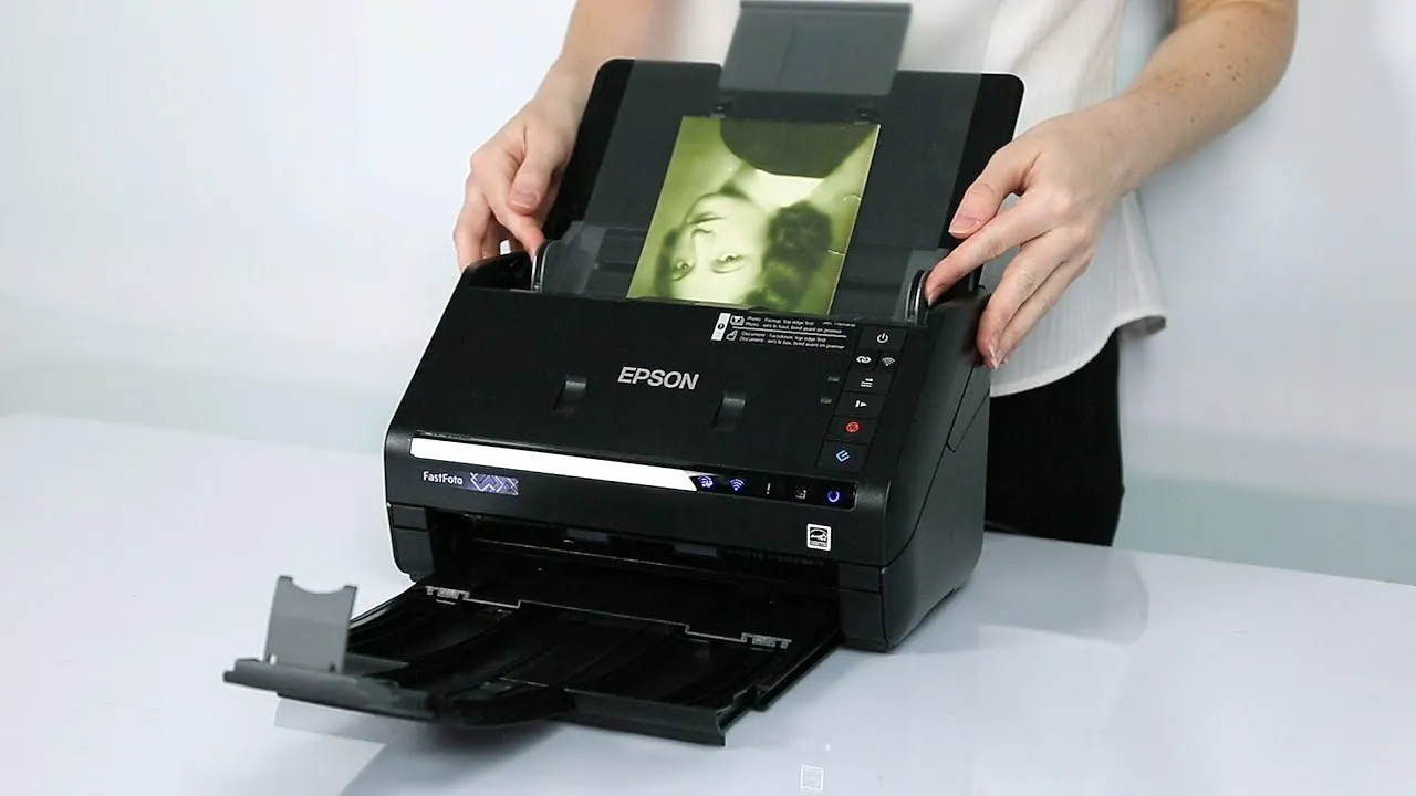Organized stacks of photographs ready for high-volume scanning on a wooden table.