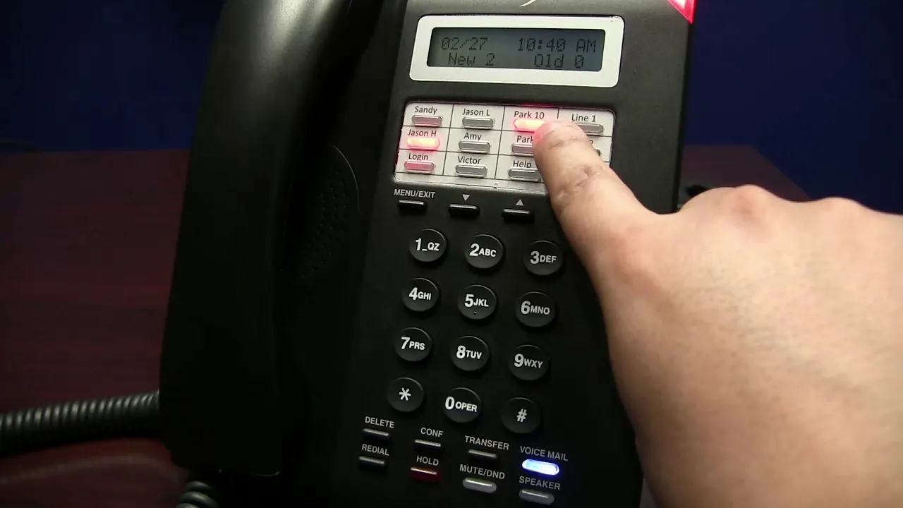 A person connects an ethernet cable to an ESI desk phone to ensure power connectivity.