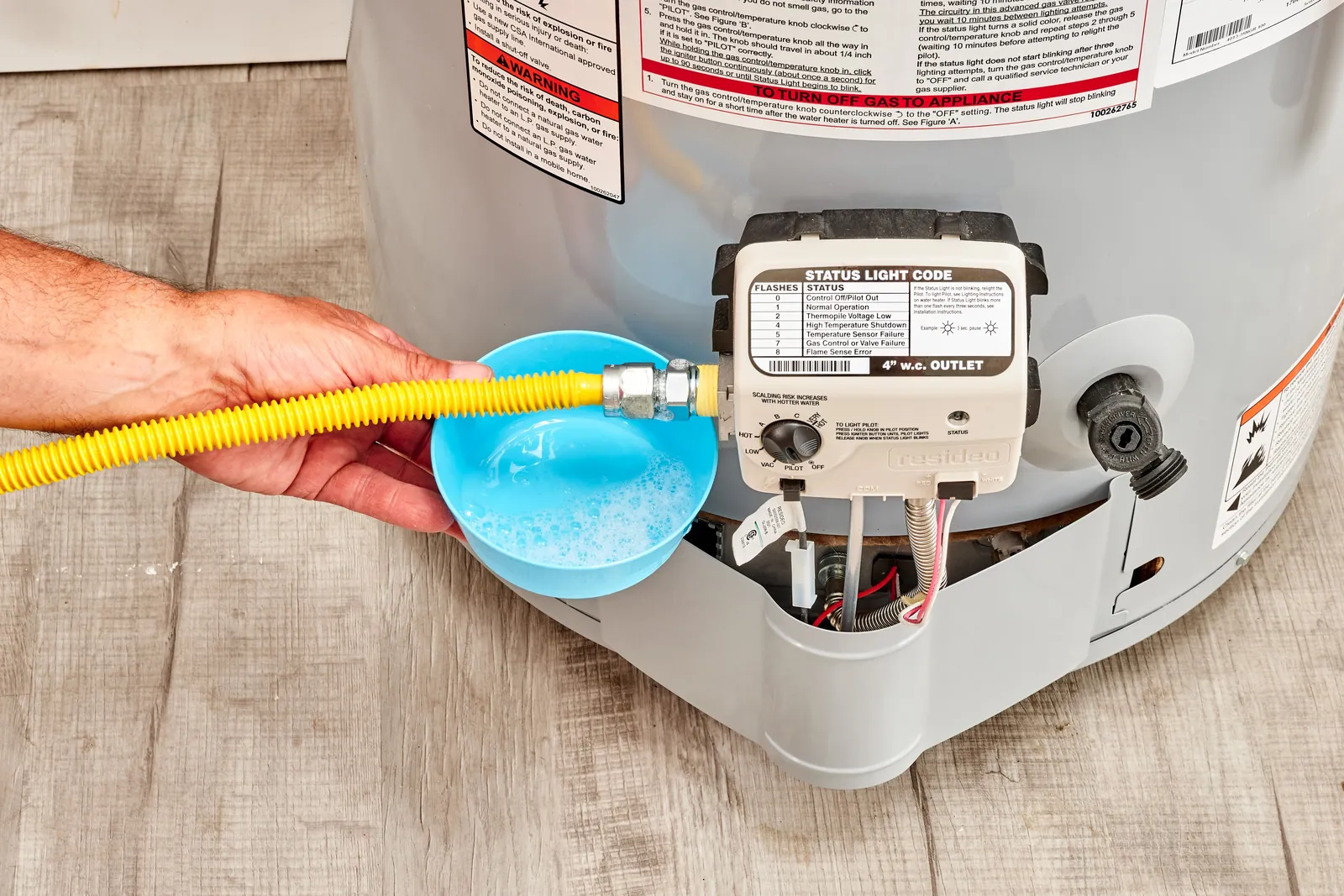 A technician turns off the power at a breaker box for safe water heater maintenance.