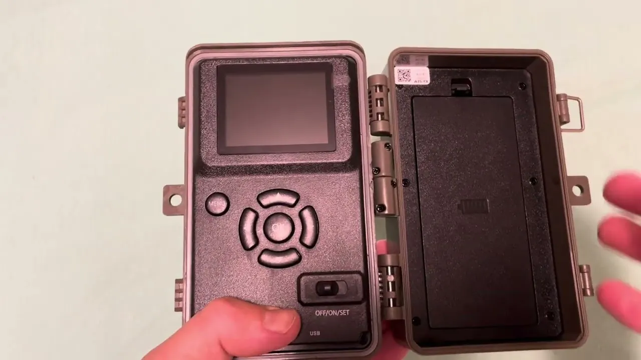 Checking batteries inside a trail camera to resolve power supply issues.