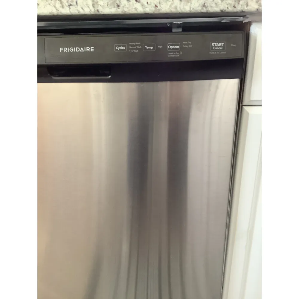 Close-up of a person cleaning the dishwasher filter screen to prevent clogs.