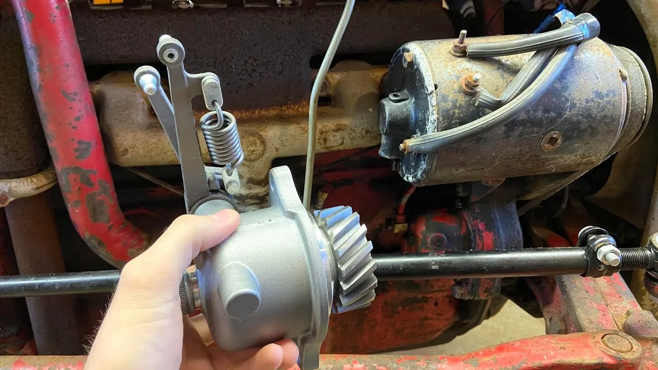 Mechanic applying oil to the linkage of a Ford 8N governor.