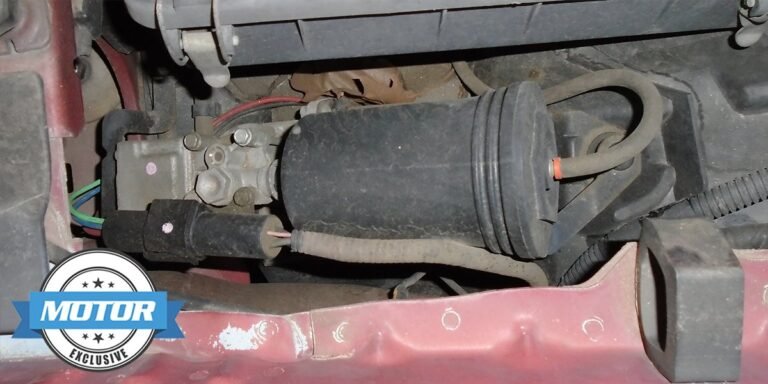 A modern SUV showing signs of a faulty air suspension system in a garage.