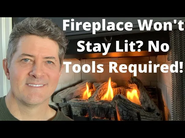 A small blue pilot light flame heats a sensor inside a gas fireplace.