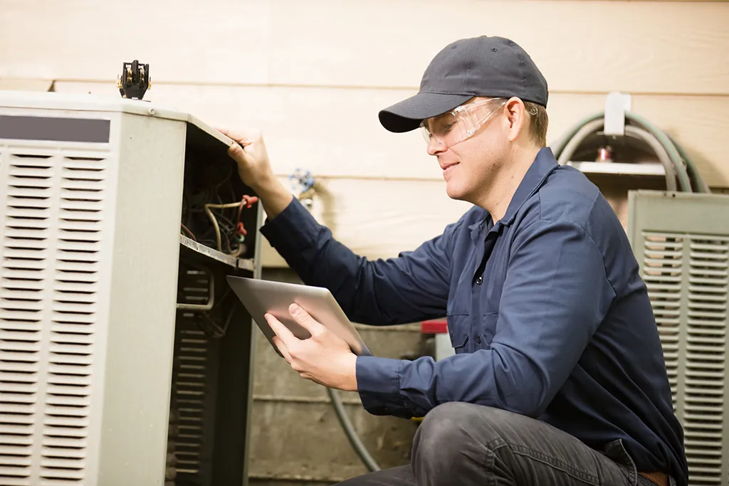 A technician checks the electrical panel to troubleshoot a First Company air handler power issue.