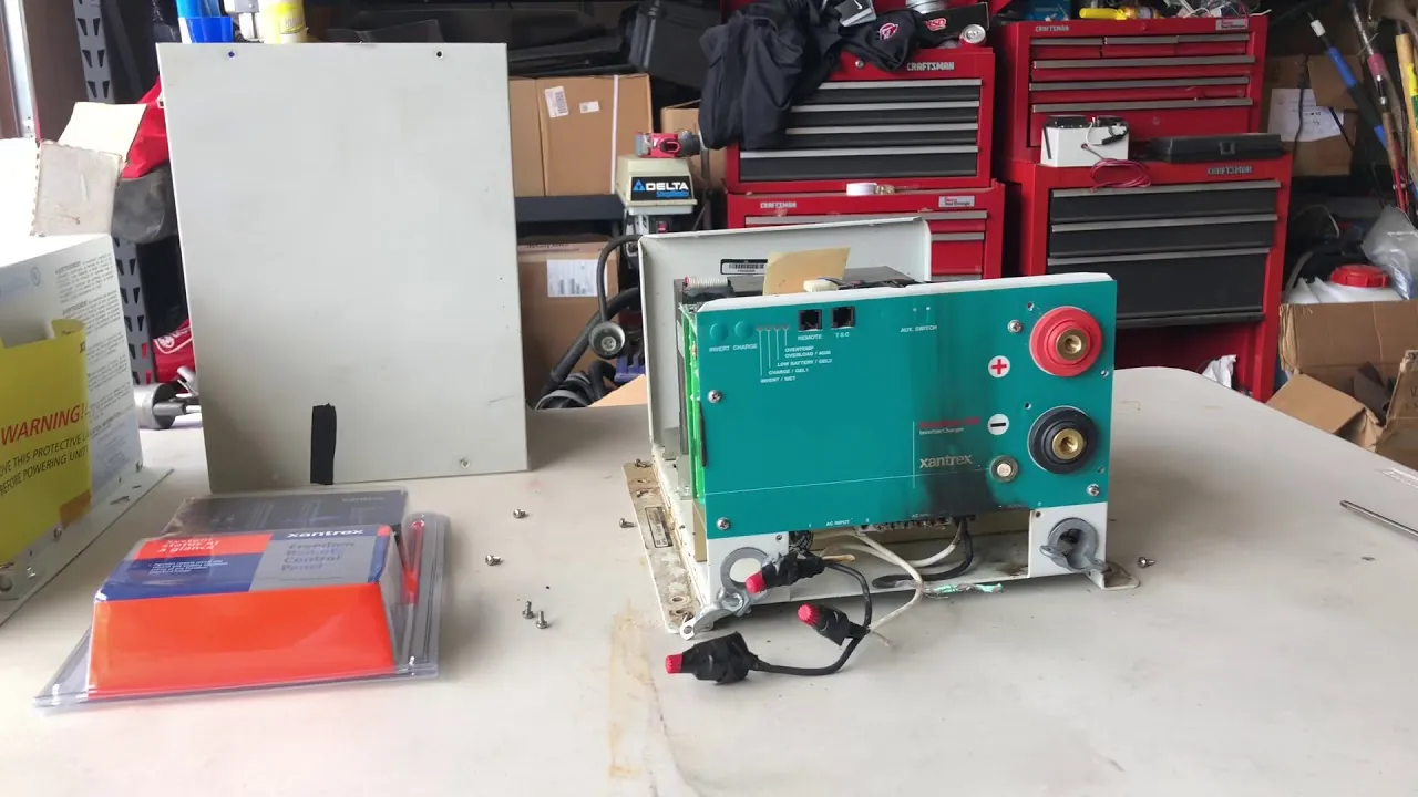A technician testing battery bank voltage to troubleshoot a Freedom Combi inverter-charger system.